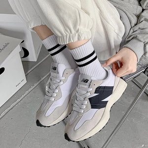 Close-up of retro grey suede sneakers paired with black and white striped cotton socks