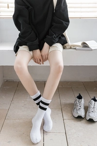 Gros plan de chaussettes blanches à rayures noires avec bords côtelés pour un look cosy