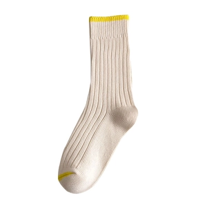 Minimalist white mid-calf socks with yellow contrast toe and heel in ribbed knit style
