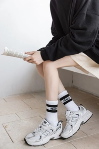 Vue détaillée des chaussettes blanches côtelées avec rayures noires et logo
