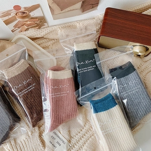 Set of cozy ribbed crew socks in assorted neutral colors on a warm knit blanket