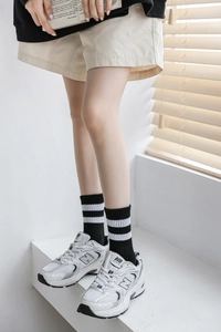 Détail de chaussettes de sport rayées avec des baskets en maille sous lumière douce