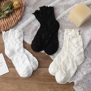 Détail du bord à volants et de la texture gaufrée sur des chaussettes en trois couleurs