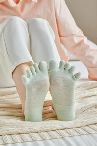 Detail of light green five-toe socks featuring breathable mesh vents and soft cotton fabric