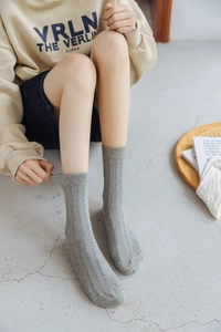 Detail of grey knitted crew socks showing elastic ribbed texture and argyle pattern