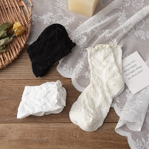 Gros plan de chaussettes vintage noir et blanc avec dentelle et texture florale