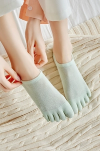 Close-up of mint green five-toe liner socks featuring breathable mesh fabric texture