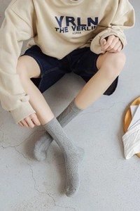 Detail showing grey crew socks with knitted argyle pattern and soft cotton texture