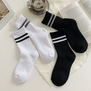Detail of cotton crew socks with ribbed cuffs and stripes on textured paper background