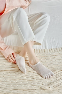 Detail of white mesh five-finger socks showing breathable knit and toe separation