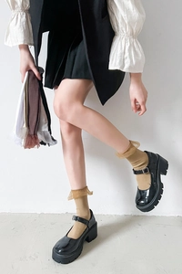Detail of ribbed velvet ruffle socks in multiple colors with stylish Mary Jane shoes