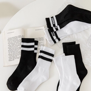 Vue détaillée de chaussettes mi-hautes en coton blanc avec rayures et lettrage noir