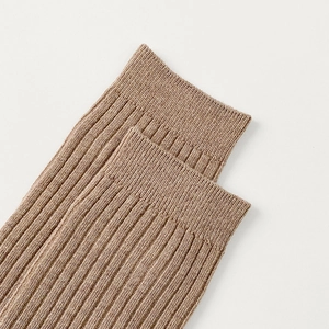 Close-up of light brown ribbed knit cotton socks showing detailed vertical stripe texture