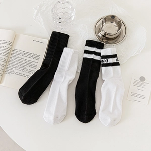 Détail de chaussettes blanches côtelées avec rayures noires et lettrage ANXI de style plat