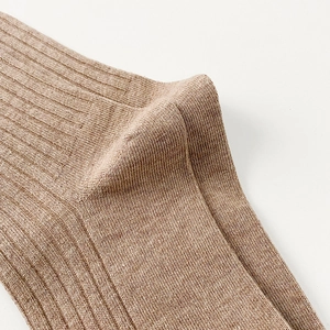 Macro detail of brown ribbed cotton knee-high socks showing fine knit texture and heel