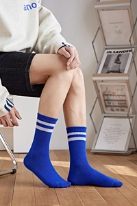 Gros plan de chaussettes bleues côtelées avec rayures blanches portées par un mannequin