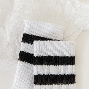 Gros plan sur des chaussettes blanches à rayures noires en coton épais côtelé