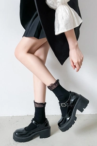 Close-up of black mesh lace trim socks with vintage platform Mary Jane shoes