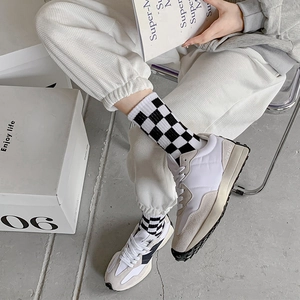Retro checkered mid-tube socks paired with vintage white and gray sneakers