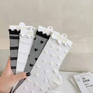 Detail showing sheer glass silk socks with cute heart patterns and delicate ruffle trim