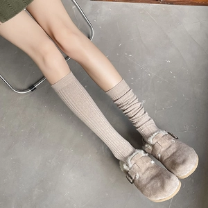Women's oatmeal ribbed knee-high cotton socks styled with warm lined mule slippers