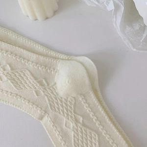 Close-up of cream white hollow knit cotton socks with vintage diamond patterns