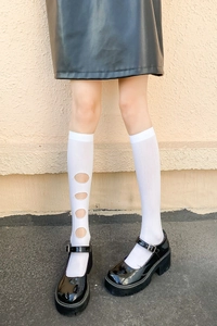 Détail de chaussettes hautes blanches Lolita avec des découpes circulaires verticales