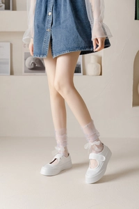 Detail of lavender lace crew socks with white bow accents and platform Mary Jane shoes