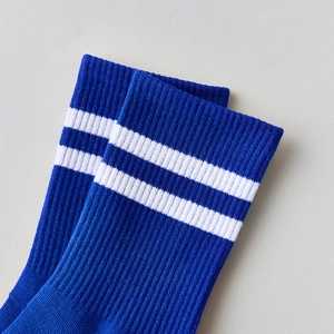 Détail de chaussettes bleues à rayures montrant la texture côtelée et les bandes blanches