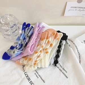 Detailed view of five pairs of colorful sheer socks with heart and dot patterns