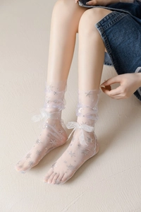 Sheer white mesh socks featuring silver snowflake patterns and delicate ankle bows
