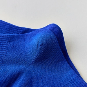 Détail d'une chaussette bleue montrant la couture du talon et la texture du coton