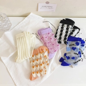 Detailed flat lay of semi-transparent sheer socks with floral and heart patterns