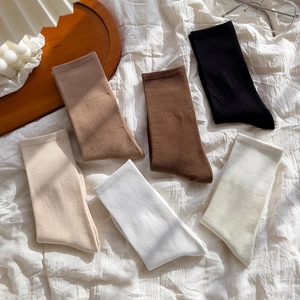 Detailed flat lay of cotton mid-calf ribbed socks in six neutral earth-tone colors