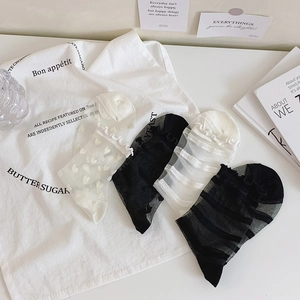 Detail of four pairs of sheer mesh crew socks with ruffle cuffs and heart patterns