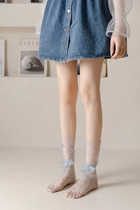 Detail of light blue sheer tulle socks featuring silver snowflake sequins and silk bows