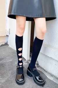 Détail de chaussettes hautes noires à découpes circulaires latérales élégantes
