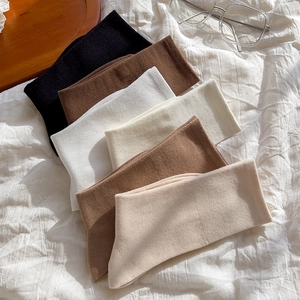 Close-up of six pairs of knit cotton mid-calf socks in diverse neutral earth tones