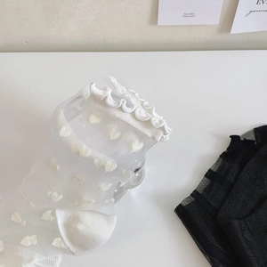 Detail of transparent glass silk socks with heart patterns and ruffle edges for women