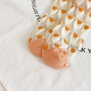 Detail of sheer white mesh crew socks with 3D orange heart patterns and reinforced toe
