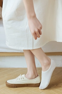 Close-up of white mesh low-cut invisible socks worn with canvas shoes for a hidden look