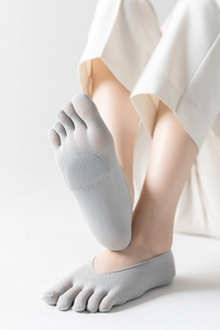 Detail of light gray five-finger invisible socks with anti-slip pads and mesh texture