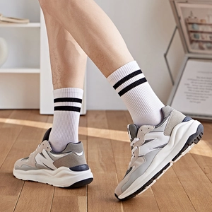 Baskets rétro gris et blanc avec chaussettes classiques à rayures noires mi-hautes