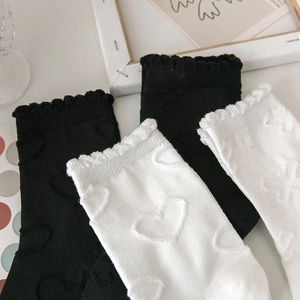 Vue détaillée de chaussettes hautes JK avec motifs de cœurs texturés et bords à volants