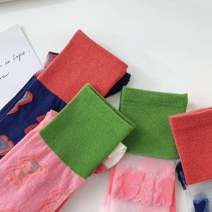 Close-up of candy-colored JK mid-calf socks featuring 3D floral and butterfly shear velvet patterns