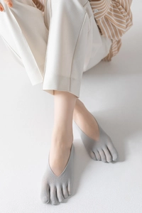 Close-up of low-cut light gray five-finger invisible socks worn with stylish casual outfit