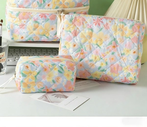 Three-piece quilted floral cosmetic bag set in light blue cotton with delicate flower patterns