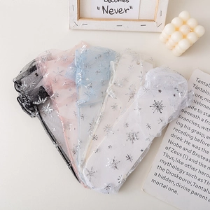 Detail of five-color mesh socks with silver snowflake patterns in a stylish flat lay