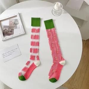 Detail view of colorful JK calf socks with pink plush patches and green ribbed cuffs