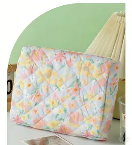 Detail of floral quilted cosmetic bag featuring soft pastel flowers and zipper closure